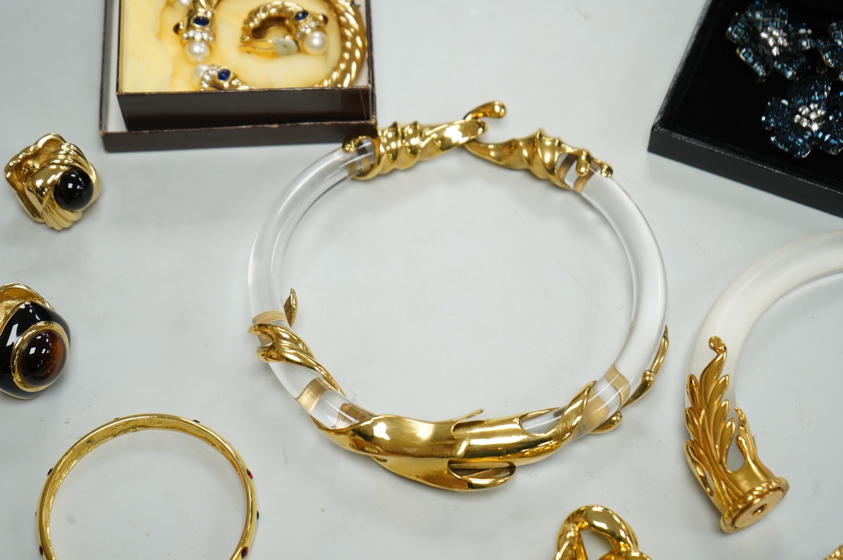 A small group of assorted costume jewellery including a 925 and paste set brooch and pair of ear clips and a gilt metal charm bracelet.
